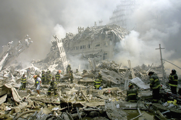 当地时间2001年9月11日,美国纽约,消防队员正在废墟中行进。 视觉中国 资料图