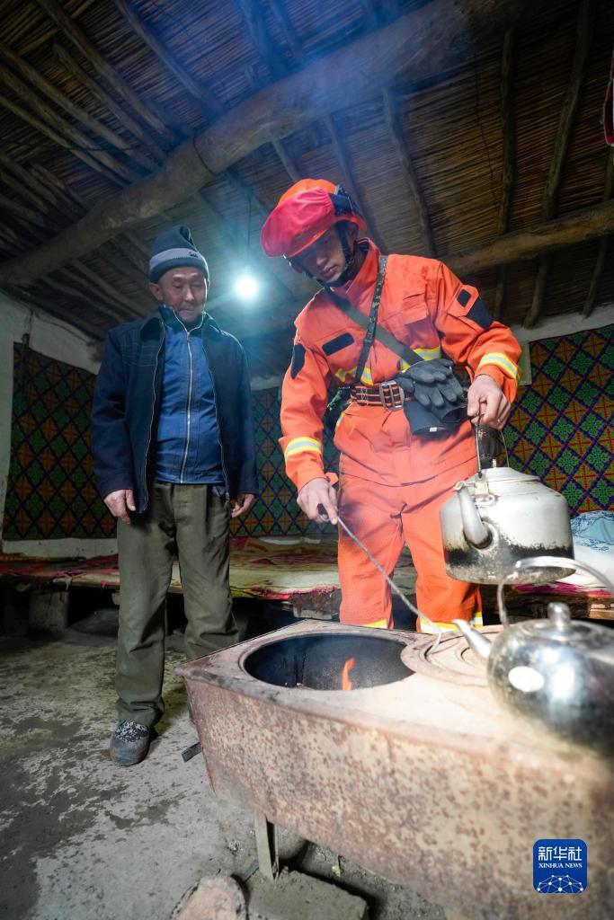 在乌苏市石桥乡马房子村，甘家湖林场应急分队队员帕勒哈提·叶勒肯向牧民哈了木哈子·吾拉孜别克介绍如何防止明火蔓延（12月4日摄）。
