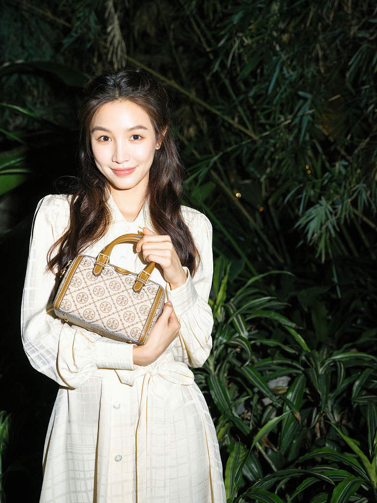 张楠一身白裙置身绿野浪漫清新 梳波浪卷发笑容甜美超养眼