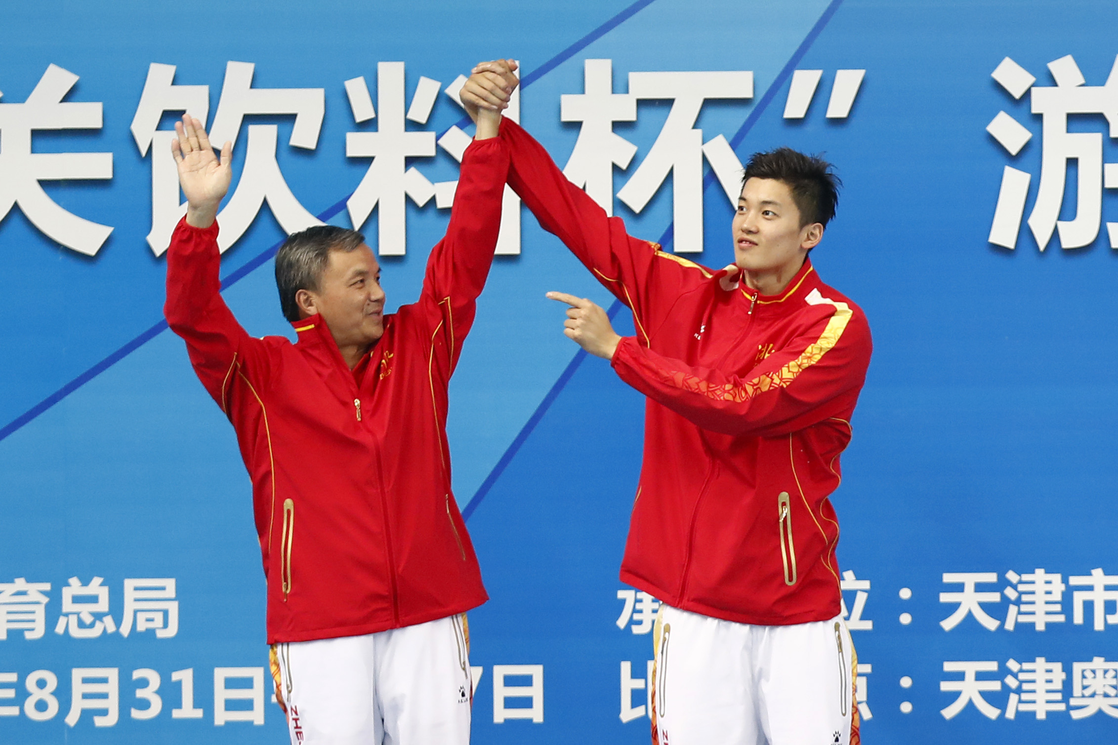 2017年全运会，汪顺将恩师朱志根拉上领奖台。