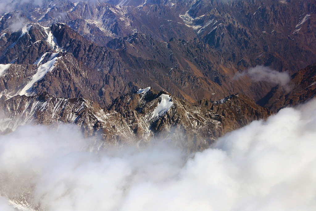 2021年3月10日,乌鲁木齐飞往阿克苏的飞机上,俯瞰新疆天山山脉,白雪覆盖气势雄壮。(图片来源:视觉中国)