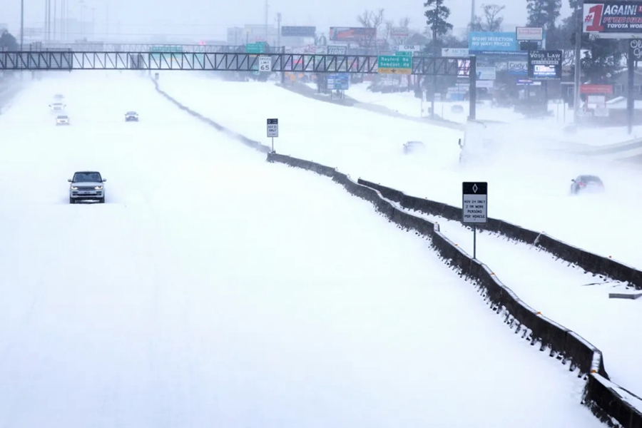 2月15日，汽车行驶在美国得克萨斯州伍德兰兹的雪地里。 本文图片均来自新华社