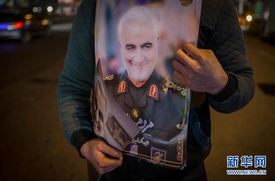  1月1日，在伊朗德黑兰，一名男子手持伊斯兰革命卫队下属“圣城旅”指挥官苏莱曼尼的肖像参加苏莱曼尼遇难周年悼念活动。 2020年1月3日，美国在伊拉克首都巴格达发动袭击，杀死伊朗伊斯兰革命卫队下属“圣城旅”指挥官苏莱曼尼等人。 新华社发（艾哈迈德·哈拉比萨斯摄）