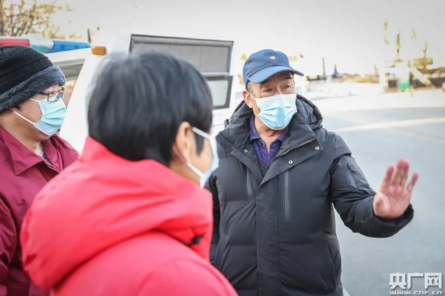 赵凤生在村口执勤点与执勤人员交谈（央广网记者 韩靖 摄）