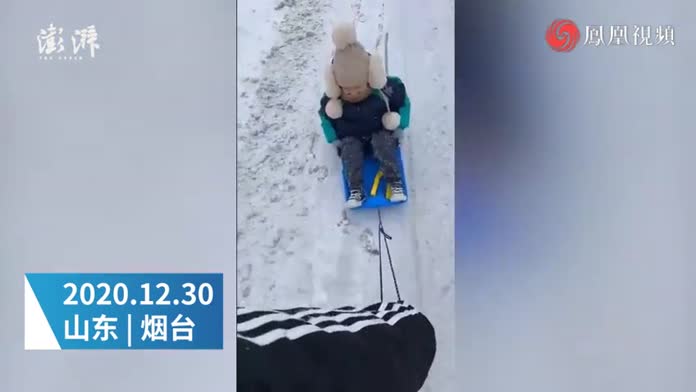 萌娃想拿全勤小奖状坚持冒雪上学，妈妈用雪板拖着送去幼儿园