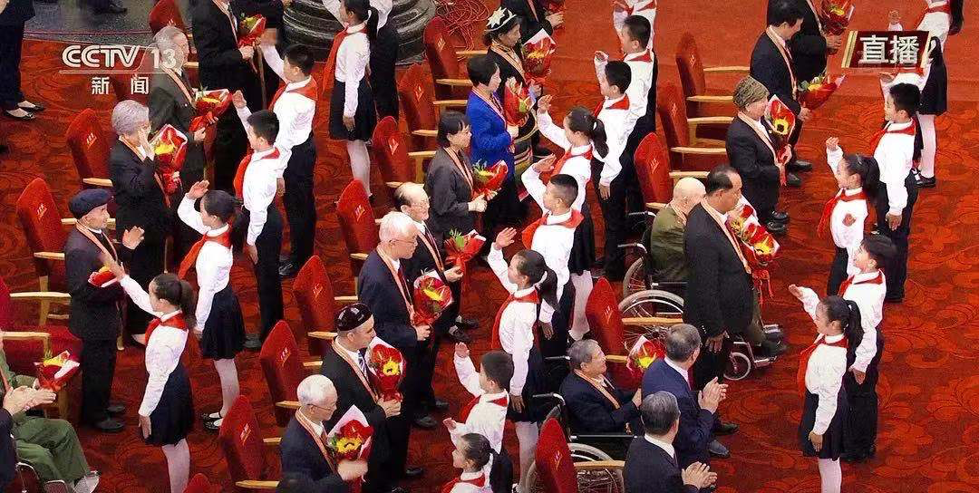 向"七一勋章"获得者献花时 握握手,拍拍头 穿军装的爷爷下意识地敬礼