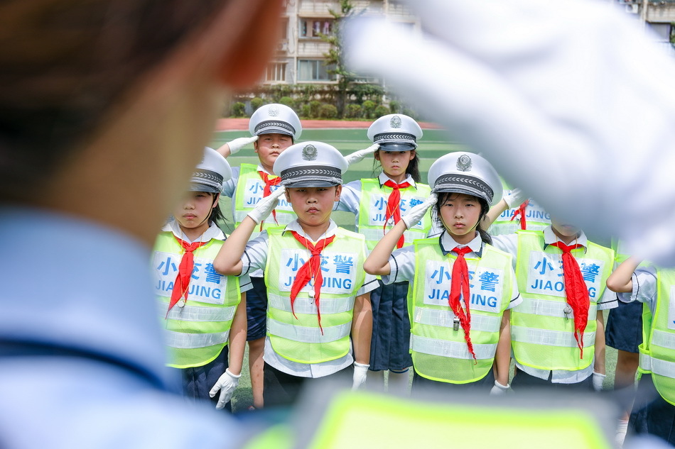 銅陵市公安局義安分局交警在操場上指導學生學習敬禮手勢