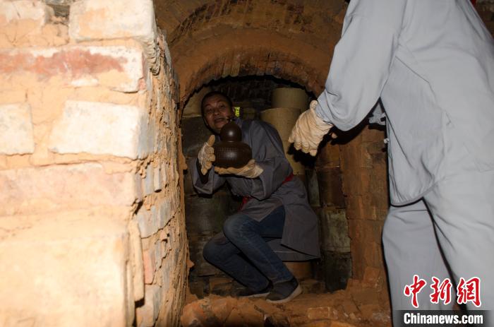 窑工在窑内拿出坭兴陶。 翟李强 摄