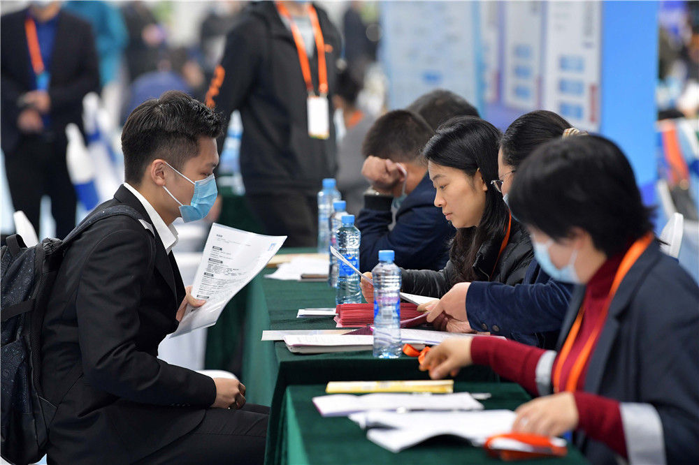 10月23日，在江西省南昌市举行的“百场校招”活动南昌大学主会场，一名毕业生（左）和一家招聘企业的工作人员交谈。新华社记者 彭昭之 摄