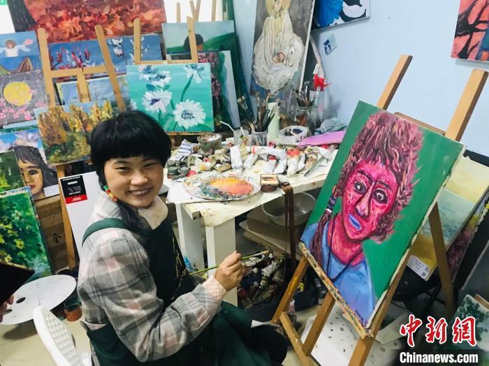 谢昕欣和她的自画像。 岳依桐 摄