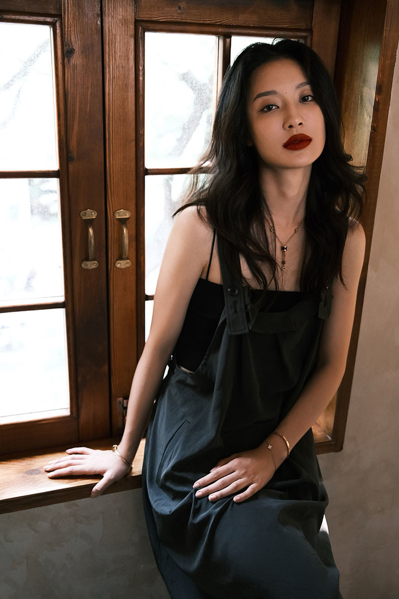 照片中,孙佳雨身着黑色背带长裙在微风中随意摆弄长发,慵懒随性中透着