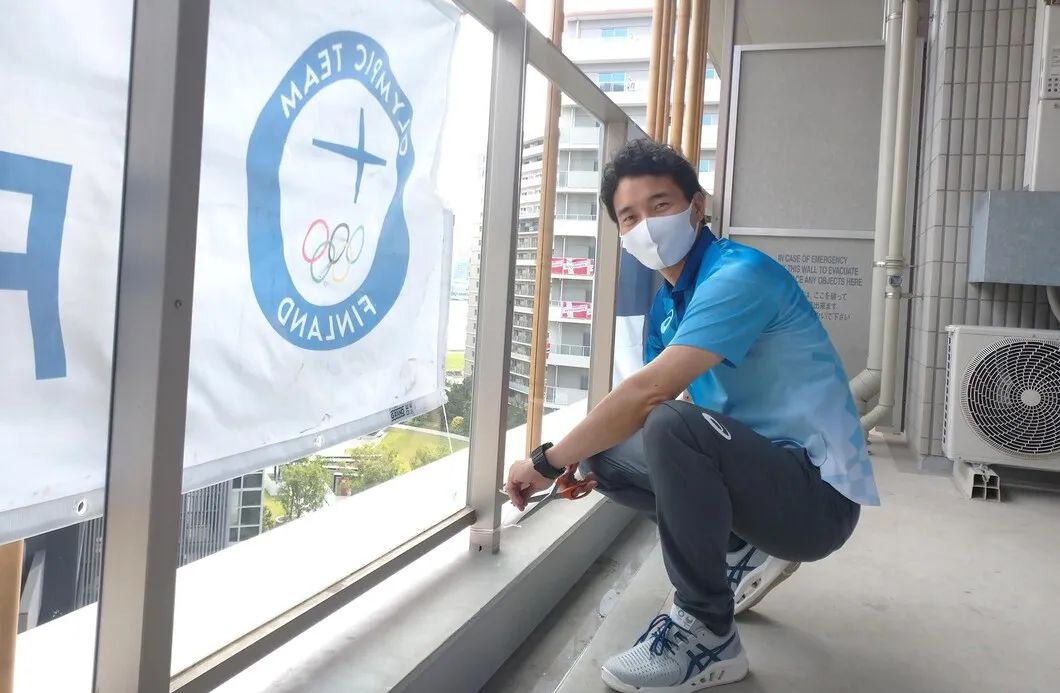 一位东京奥运会志愿者在窗边拍照。图/Tokyo 2020