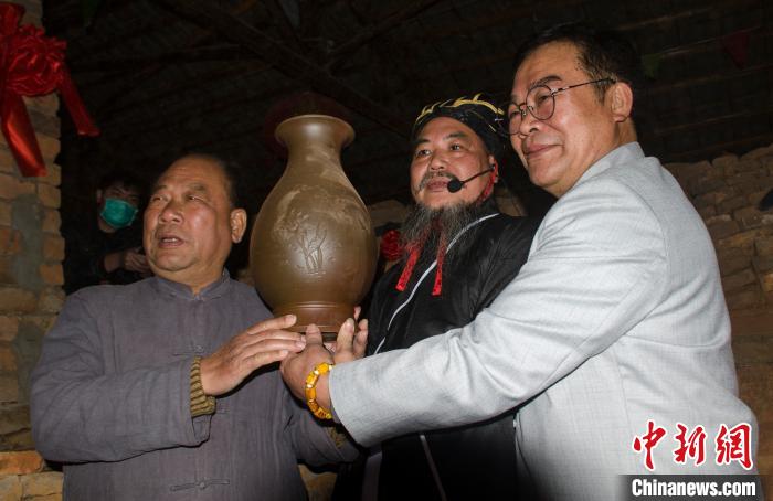 两名国家级非遗代表性传承人——李人帡(左)和陆景平(右)展示刚出窑的坭兴陶瓶。 翟李强 摄