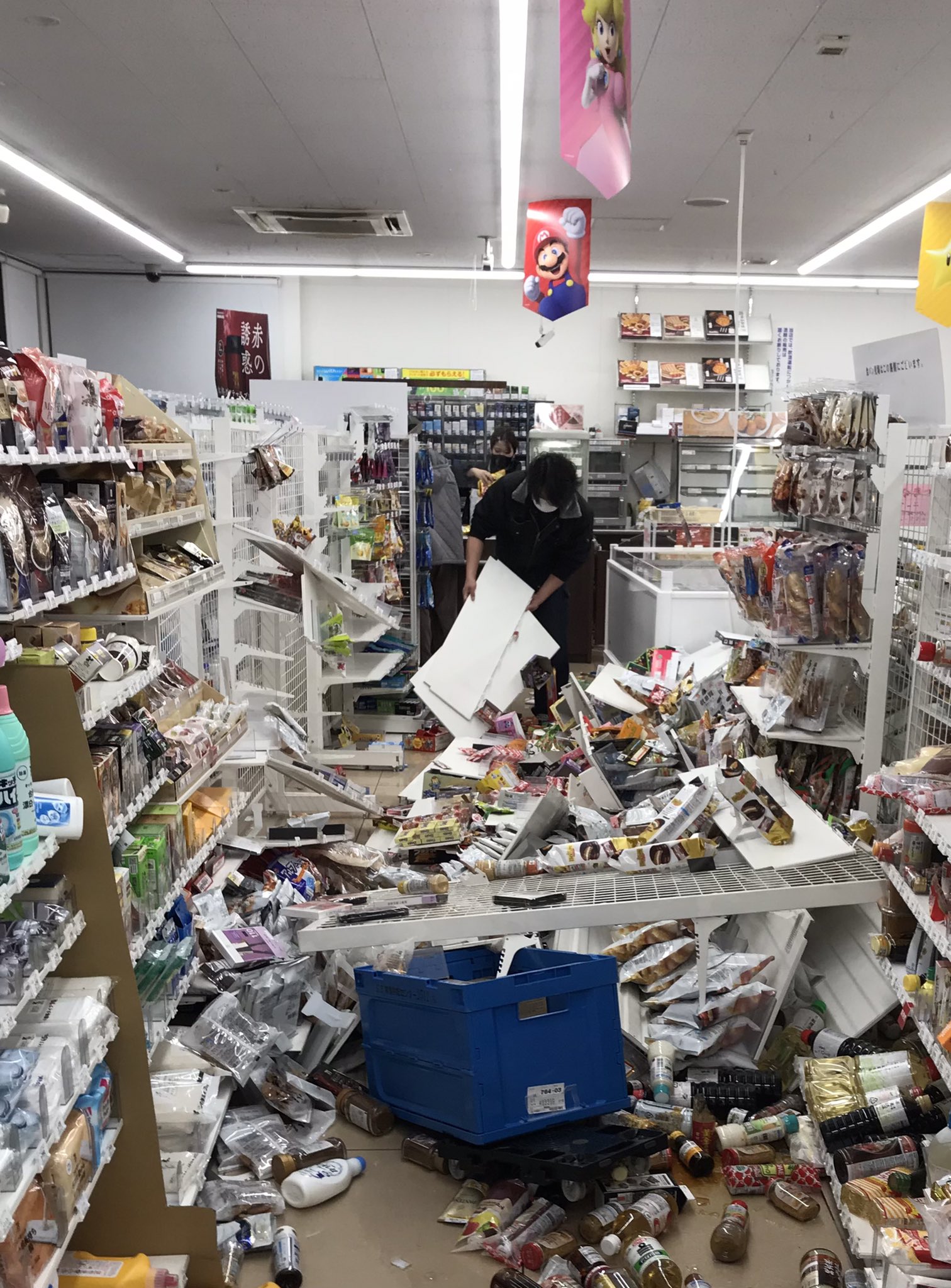 福岛市一家便利店店员正在收拾地震后散落一地的货物。图源:社交媒体