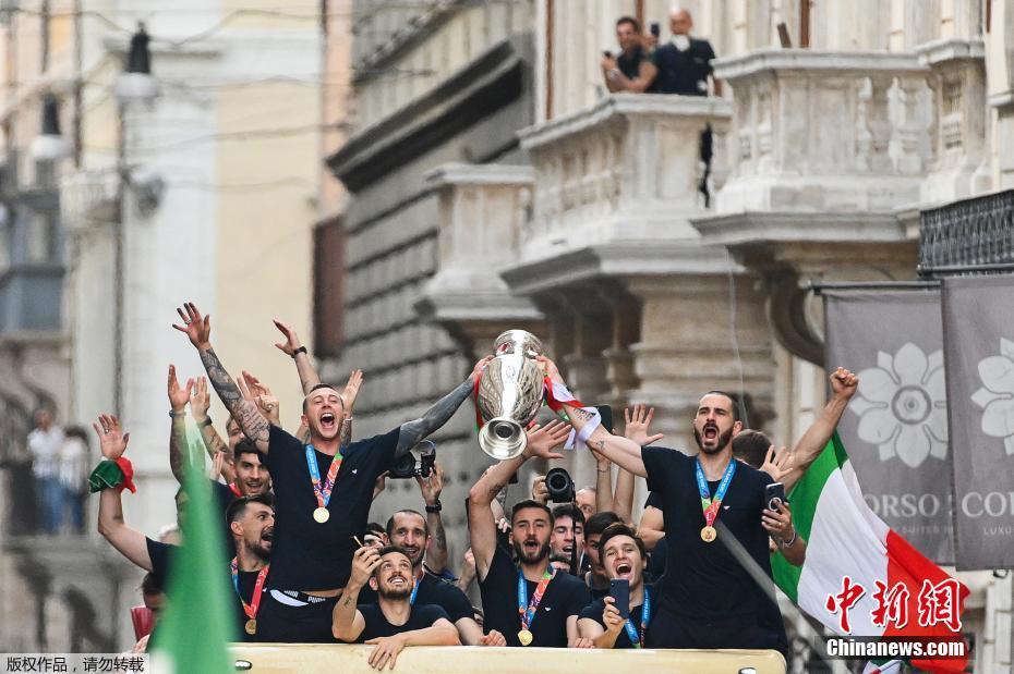 当地时间7月12日,意大利国家足球队夺得欧洲杯冠军第二天,在罗马举行冠军奖杯游行。图为意大利球员举起奖杯。