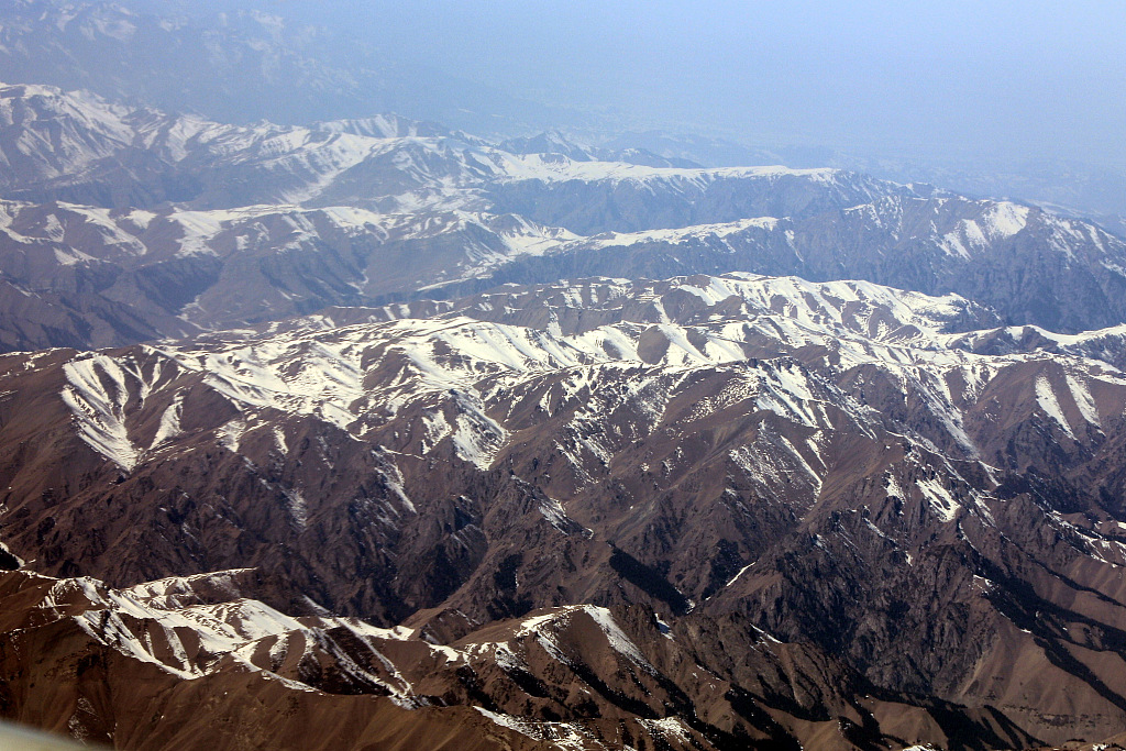 2021年3月10日,乌鲁木齐飞往阿克苏的飞机上,俯瞰新疆天山山脉,白雪覆盖气势雄壮。(图片来源:视觉中国)