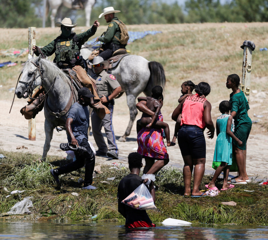 2021年9月19日,美墨边境,美国边境执法人员骑马与非法移民对峙,阻挡他们涌入美国。