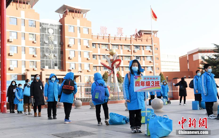  1月28日，石家庄精英中学门前，学生在冷风中等待家长接走。当天，此前因突发疫情被封闭在校园内的学生开始解封，校内学生陆续离校返家。据了解，随着疫情的变化，石家庄开始有序解封疏散封闭在中小学校园的学生。图片来源：视觉中国