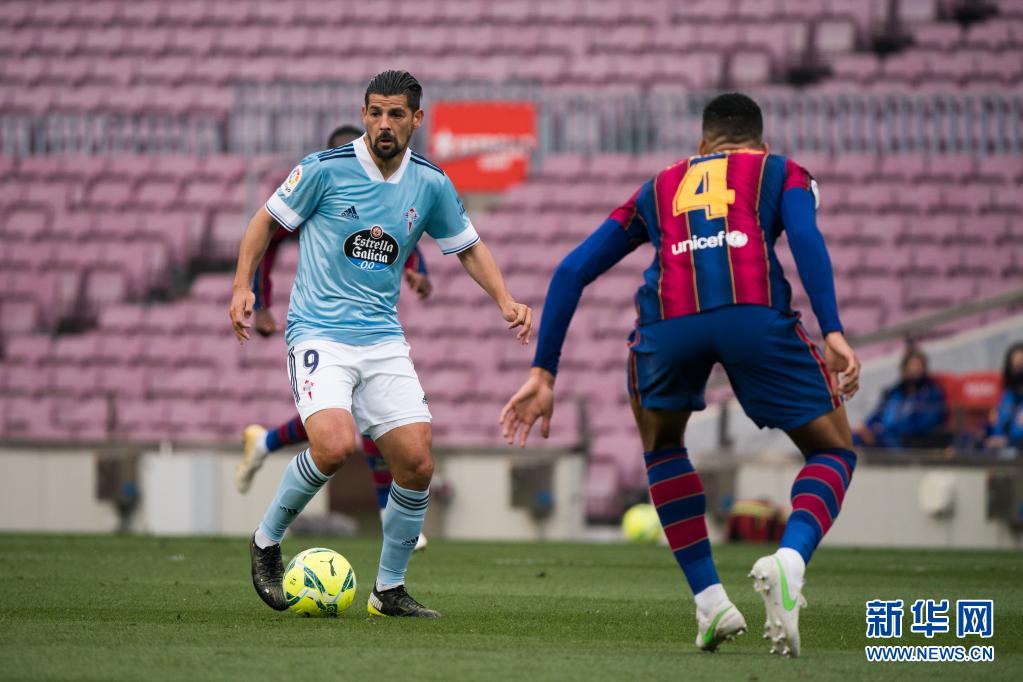 5月16日,巴塞罗那队球员阿劳霍(右)与塞尔塔队球员诺利托在比赛中拼抢。 当日,在2020-2021赛季西班牙足球甲级联赛第37轮比赛中,巴塞罗那队主场以1比2不敌塞尔塔队。 新华社发(胡安·戈萨摄)