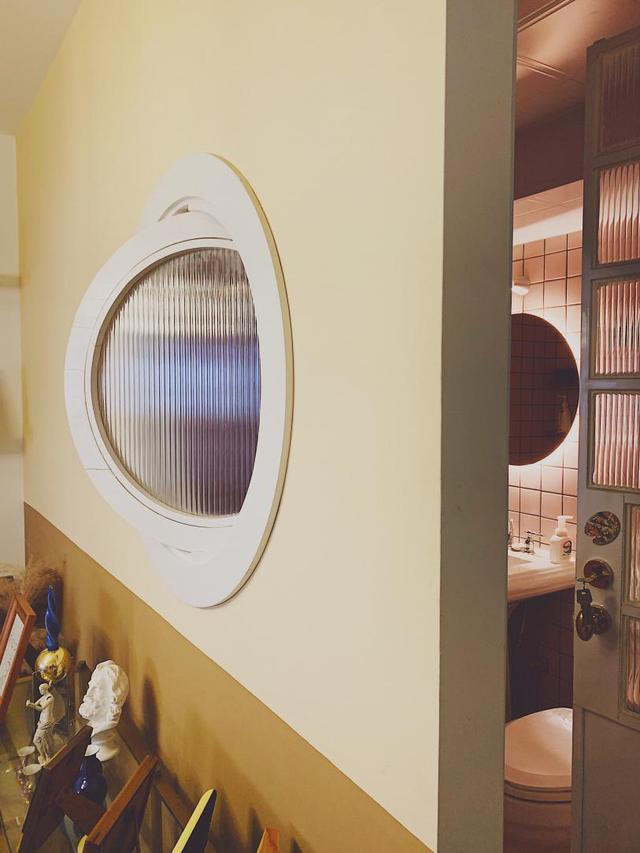 整个客厅最特别的是这个暗窗,借鉴潜水艇舷窗的样子做了圆形,订做了木