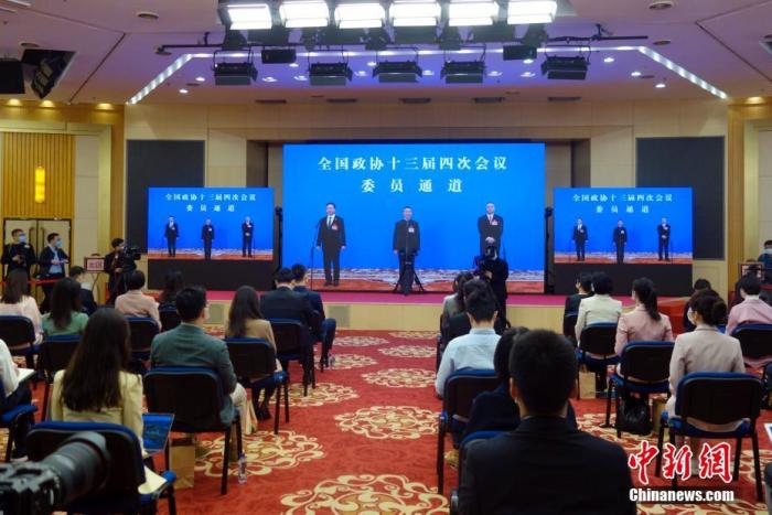 3月7日，全国政协十三届四次会议第二场“委员通道”采访活动在北京人民大会堂新闻发布厅举行。图为记者在分会场屏幕前采访。 中新社记者 温孟馨 摄