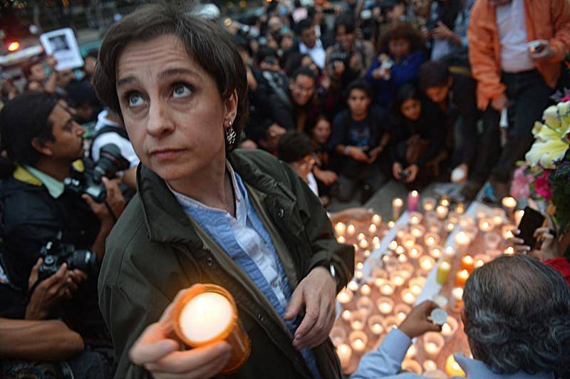 2012年5月，多名墨西哥记者被残忍谋杀，卡门·阿里斯特吉和其他同事、被谋杀记者的亲戚和朋友在墨西哥城天使独立纪念碑前竖立的祭坛上放置蜡烛和照片，抗议针对媒体的暴力行为。图片：AFP