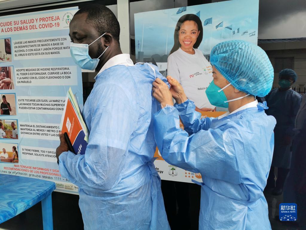 2020年6月1日，在赤道几内亚首都马拉博一所收治新冠患者的定点医院，中国抗疫医疗专家组成员帮助当地同行整理防护服。新华社发（专家组供图）