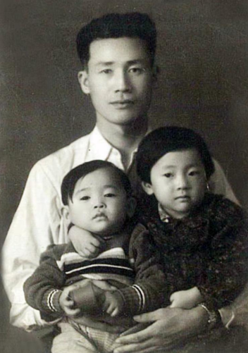 吴国璋生前怀抱儿子吴继璋(左)和女儿吴晓静(右)的合影。 吴继璋提供