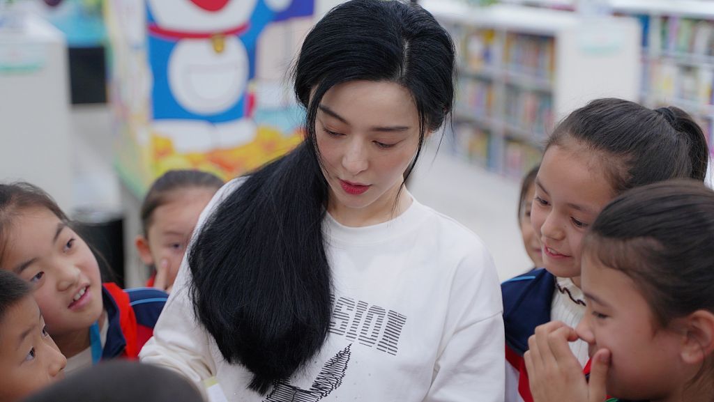 范冰冰新疆参加公益活动似邻家姐姐 看望小朋友捐赠图书