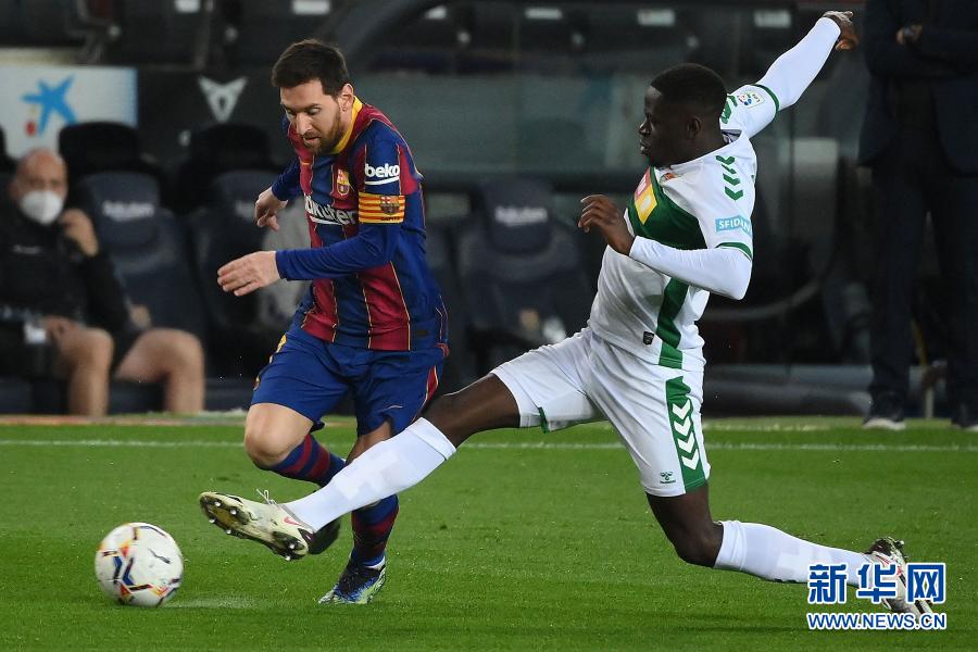 2月24日,巴塞罗那队球员梅西(左)在比赛中和埃尔切队球员穆弗鲁拼抢。 当日,在2020-2021赛季西班牙足球甲级联赛第一轮的一场补赛中,巴塞罗那队主场以3比0战胜埃尔切队。 新华社/法新