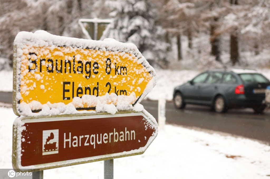 当地时间2021年11月27日,德国萨克森-安哈尔特,汽车驶过哈尔茨山区积雪覆盖的树干。在未来的几天里,雪线还会继续下降,低地地区也将下雪。