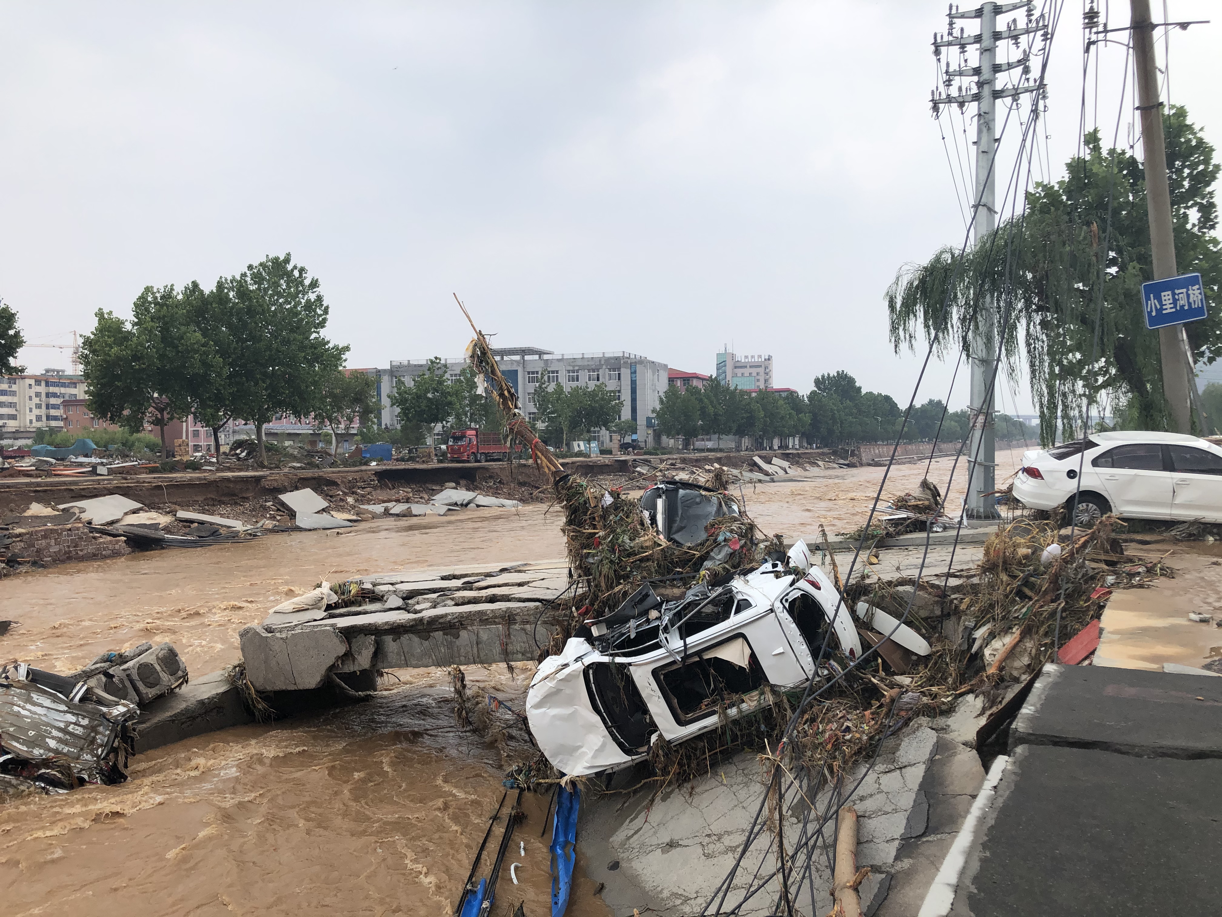 洪水中被冲垮的小里河桥和损毁的车辆。这座桥原本横跨汜水河，连接小里河村与东竹园村。澎湃新闻记者 王健