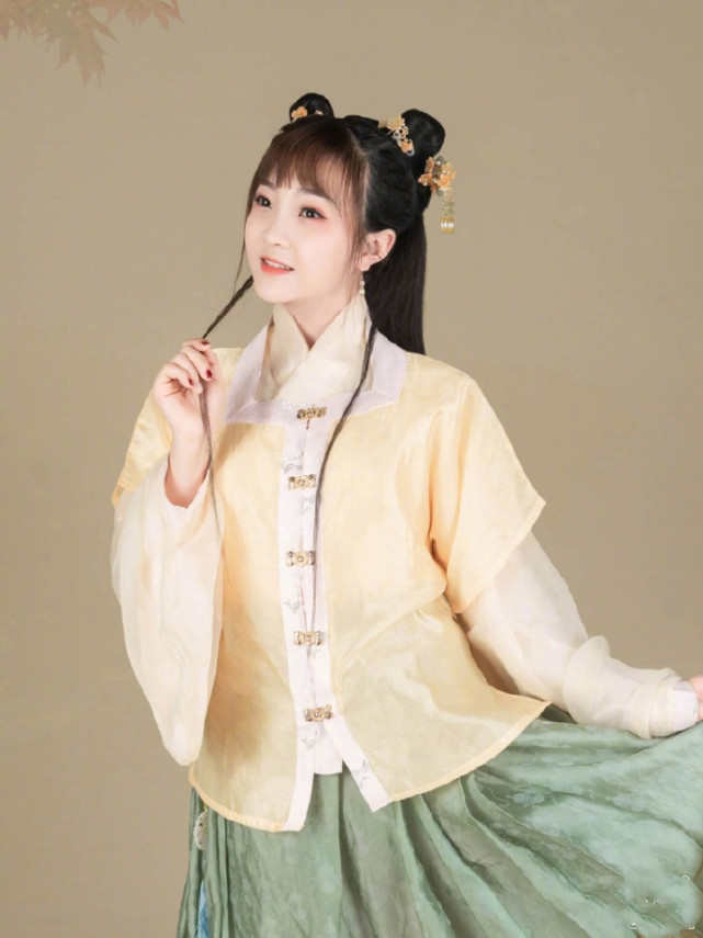 照片中,林妙可或梳着双丸子头,穿着黄色上衣与半裙古装,十分可爱;或