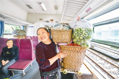 在贵州省遵义市汇川区境内的娄山关站，村民背着自产的蔬菜登上列车，准备前往桐梓县城销售。