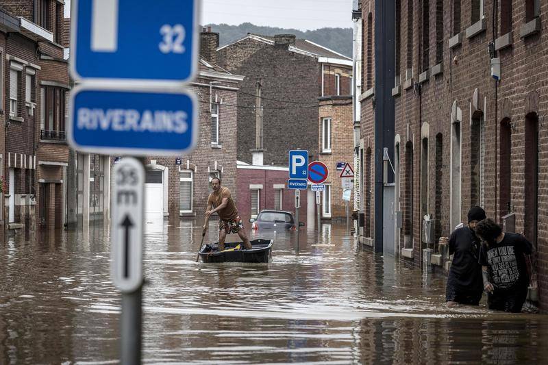 当地时间7月16日，比利时列日省安格勒，洪水过后，街道变河道，一名男子划船行驶。