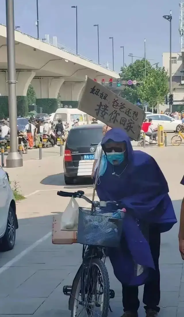 父亲在郑州地铁5号线入口,穿雨衣等孩子:妞妞,爸爸还想接你回家