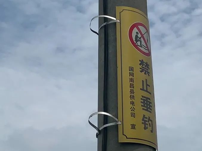 电线杆上明显挂有禁止垂钓的警示牌.