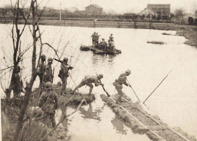 上海江湾镇的河边一队倭寇正在划船渡河,远处就是江湾镇的房屋