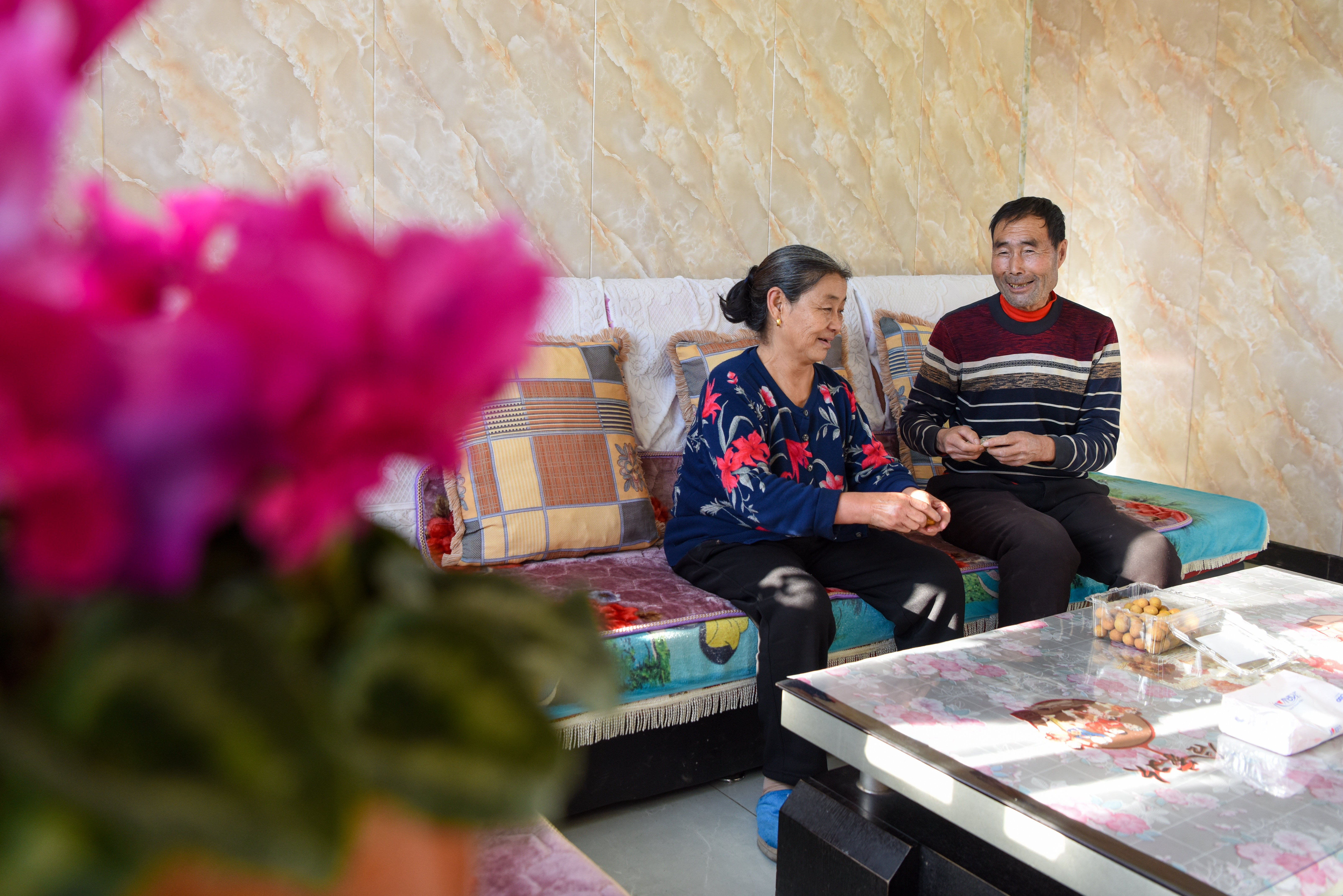 1月21日,在吉木萨尔县头工街东村,村民杨万里(右)和妻子在客厅聊天.