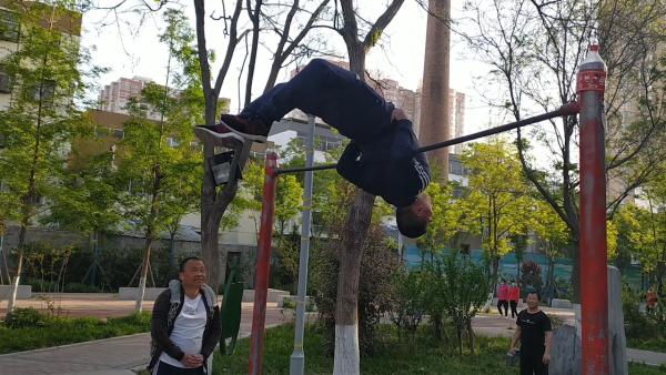 男子单杠上灵活旋转未来想继续挑战吉尼斯