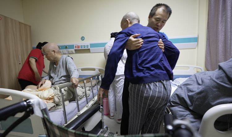 要照料40名老人的他带着瘫痪母亲去上班