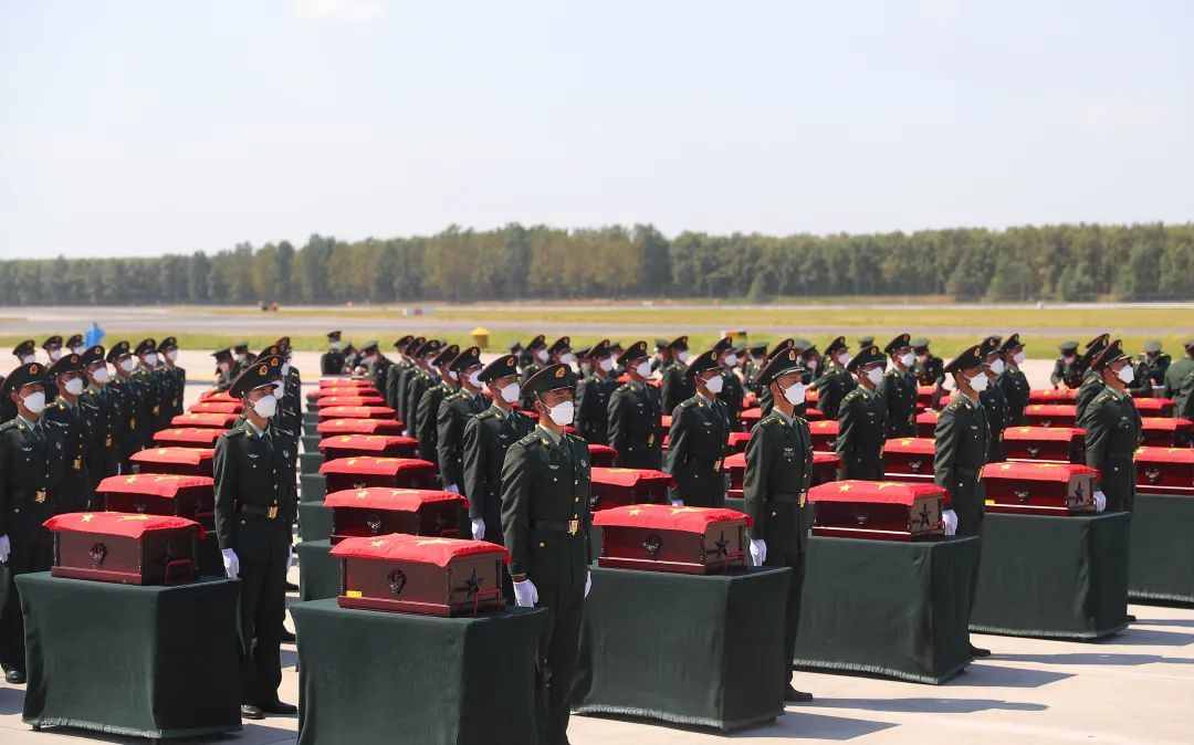 2日,在沈阳桃仙国际机场,礼兵在殓放志愿军烈士遗骸的棺椁上覆盖国旗