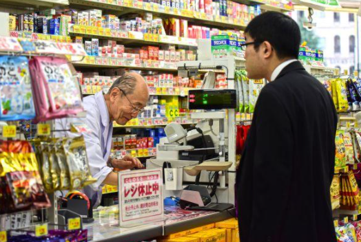 ▲日本东京涩谷区的一家药妆店内，一位老年工作者正在为顾客服务。图据视觉中国