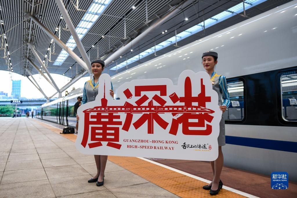 2018年9月23日，广深港高铁全线开通运营，从深圳北站开往香港西九龙站的G5711次高铁列车乘务员展示纪念牌。新华社记者 毛思倩 摄