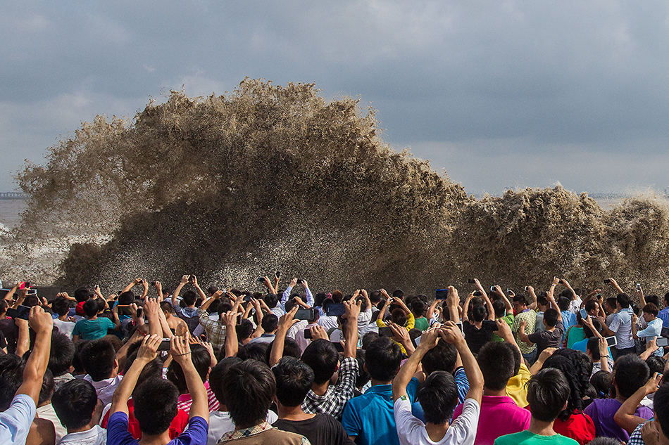 2013年9月22日,杭州,农历八月十八,加上超强台风“天兔”外围影响,钱塘江潮水在杭州下沙七格段撞击江堤后掀起巨浪,观潮者纷纷举起手机拍照,记录壮观大潮。