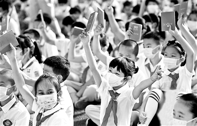 十一学校一分校的孩子们手举“开学护照”参加开学典礼 摄影/本报记者 崔峻