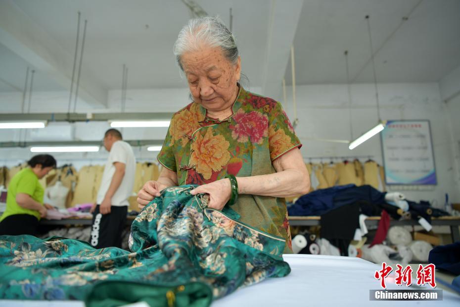 6月2日,河北石家庄"旗袍奶奶"靳玉霞正在自家的制衣工作间忙碌.