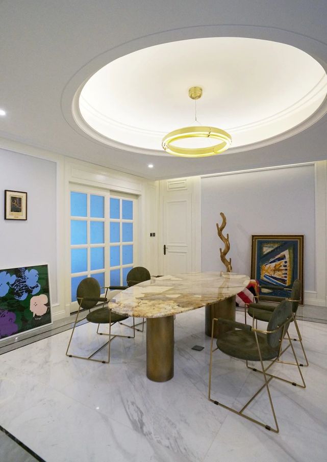 椭圆形餐桌与圆形吊顶,为空间带来一丝柔和之美,利用家具来降低空间