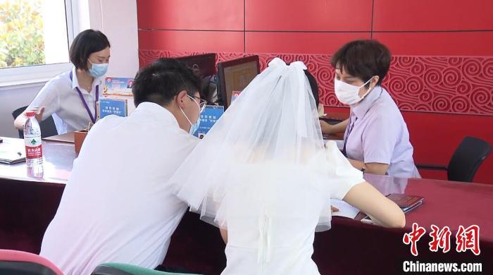 资料图：穿着婚纱登记结婚的新人徐楚淇和爱人。 杨季峰 摄