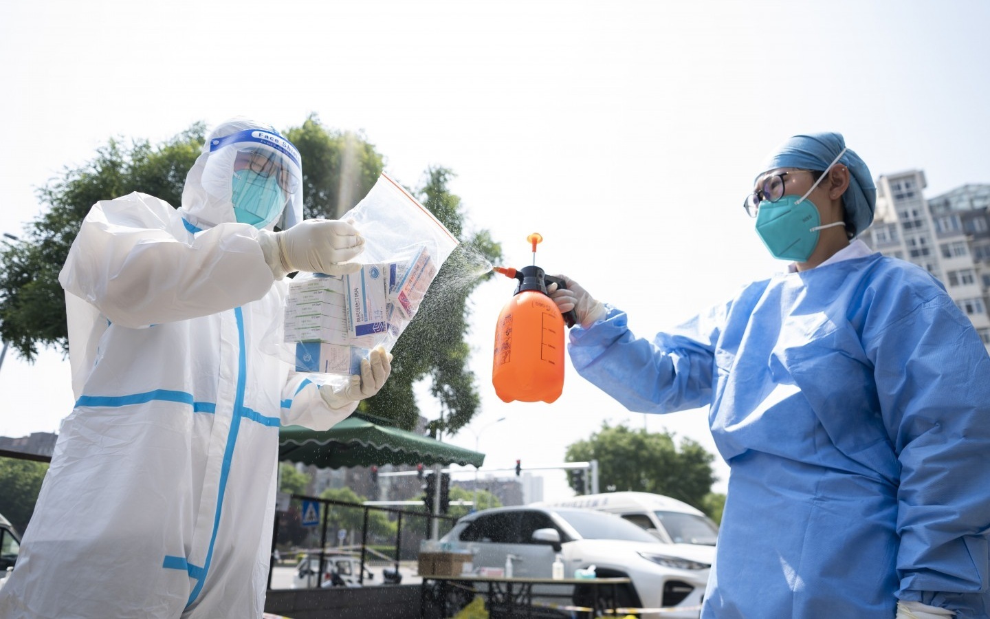 志愿者将药品装入密封袋后，对外层袋子进行消毒。新京报记者 陶冉 摄
